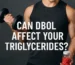 Athlete curling a dumbbell while holding a jar of red tablets with the headline “Can Dbol affect your triglycerides?”
